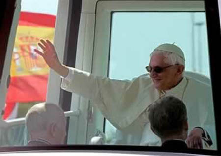 A waving Benedict XVI wearing sunglasses